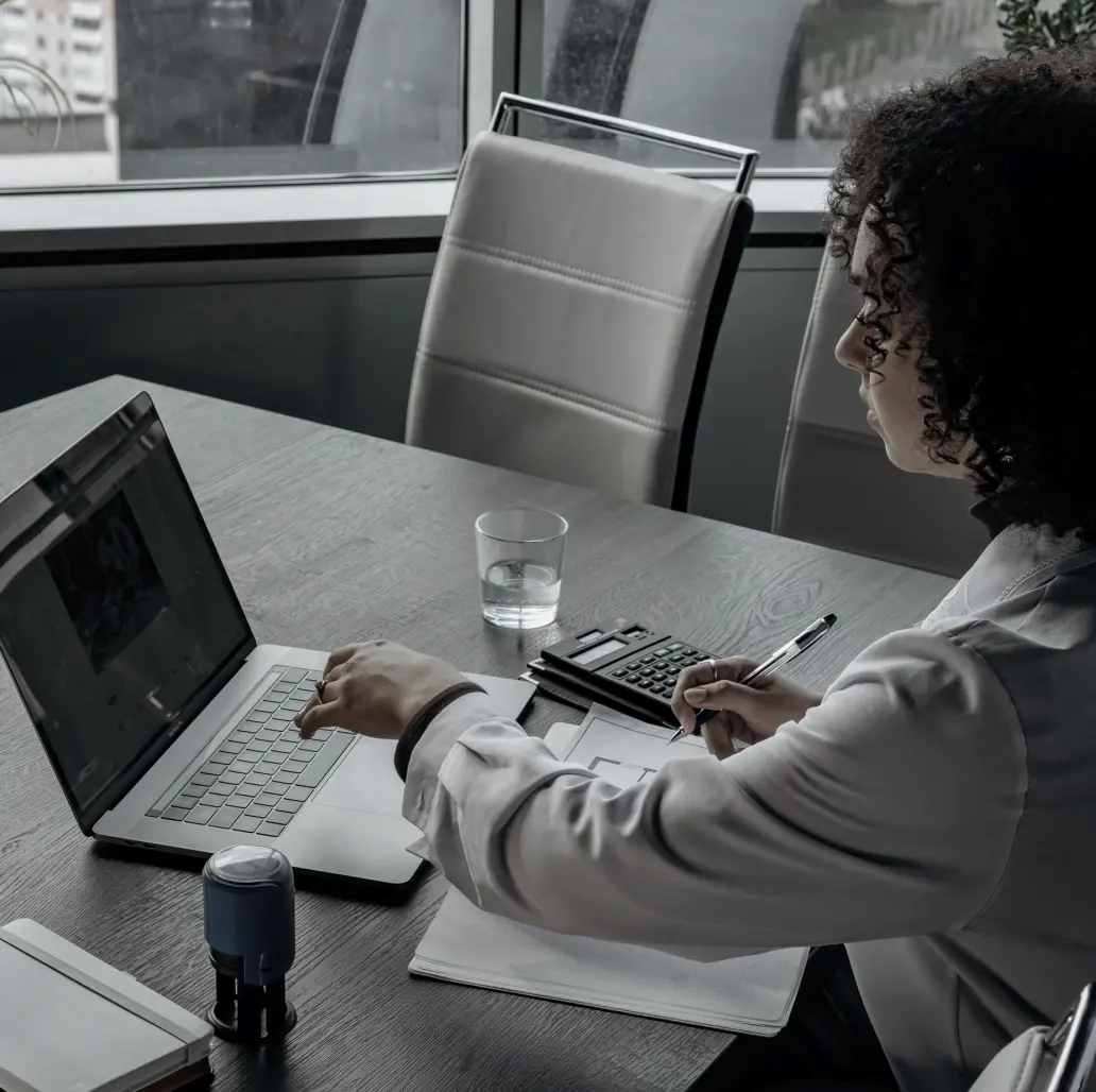 Woman sitting at computer taking notes